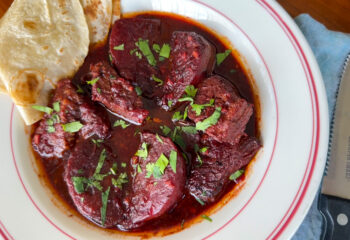 Roasted beef with beets and red chile sauce, with a tortilla on the side