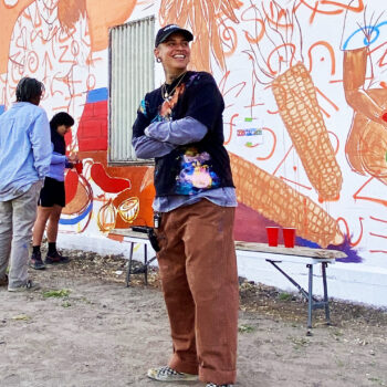 Jade Cruz stands in front of the mural in progress in downtown Albuquerque.